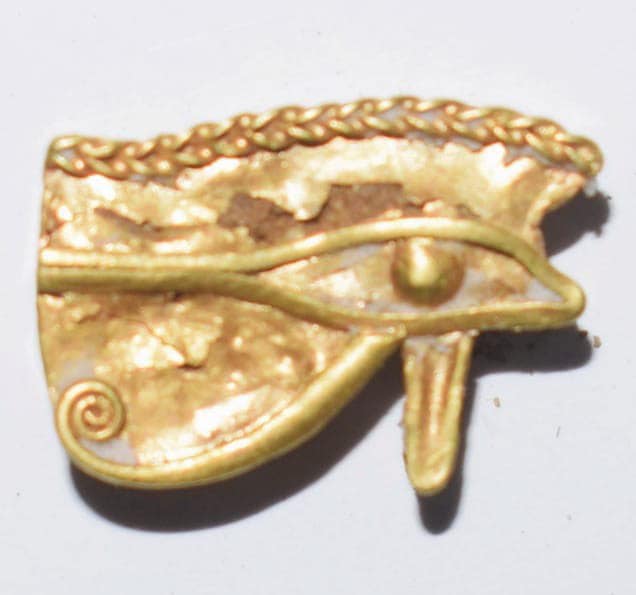 A golden amulet with the shape of the "Eye of Horus". Credit: Ministry of Antiquities / Facebook