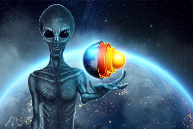 A gray alien, humonoid, holds a hologram of the globe on his hand. Depositphotos.