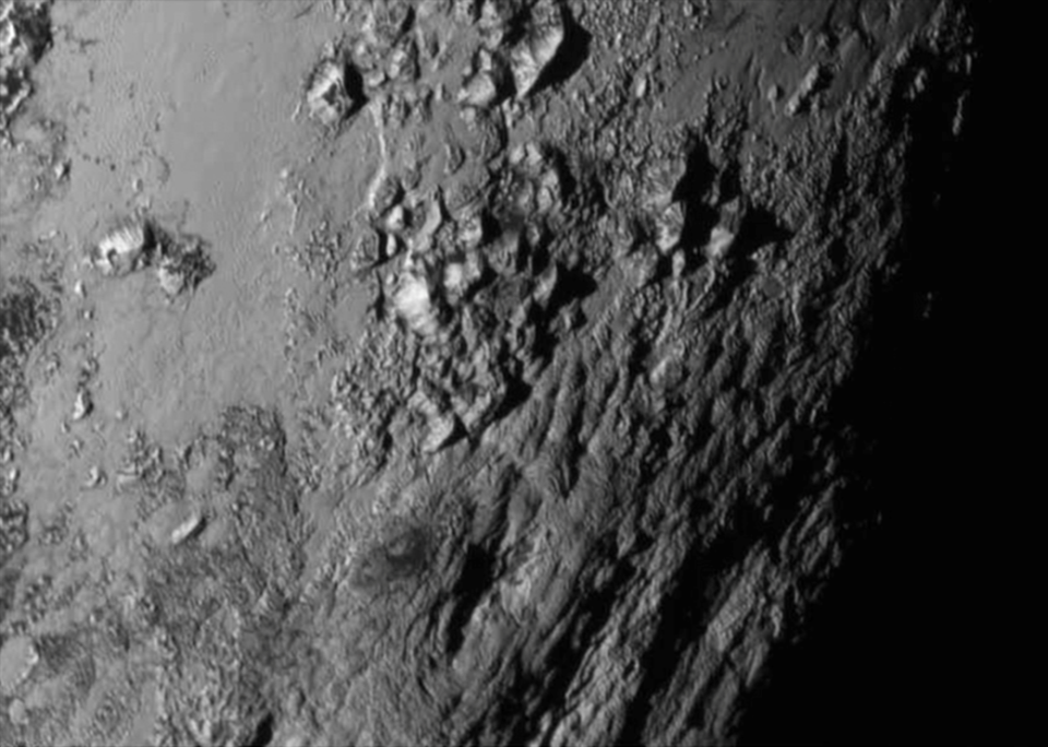 The first image taken during the New Horizons rendezvous with Pluto showing mountains on the surface of the planet. Credit: NASA