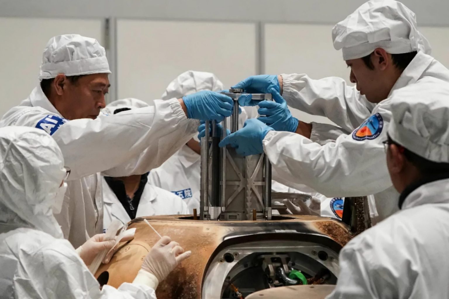 Experts remove a container with lunar samples from the landing capsule. Credit: Fu Yifei / Science and Technology Daily.