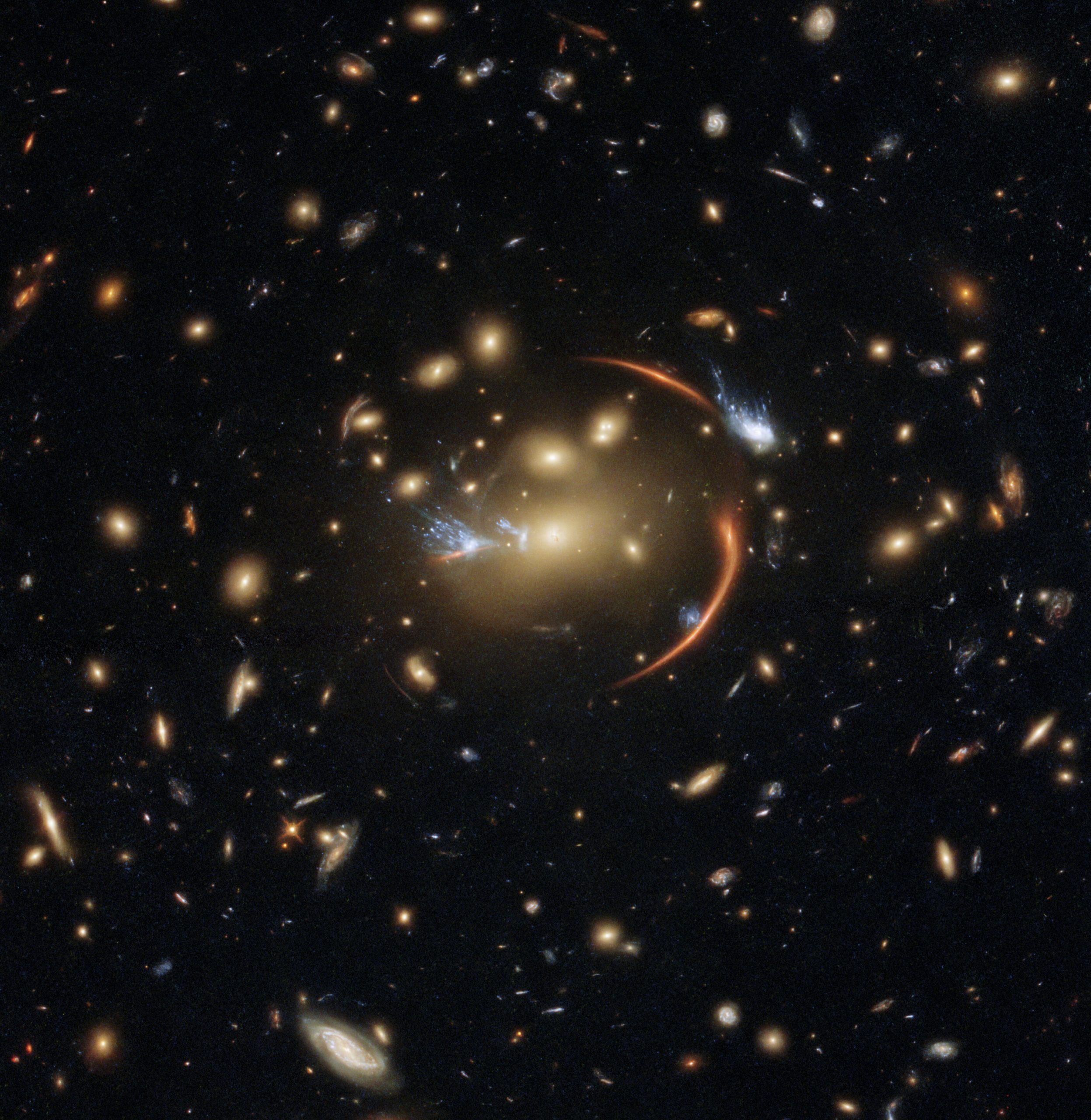 August's image includes the nearby galaxy cluster dubbed MACSJ0138.0-2155, which is an incredible example of gravitational lensing as we see glimpses of a far more distant galaxy where stars no longer form. Credit: ESA/Hubble & NASA, A. Newman, M. Akhshik, K. Whitaker