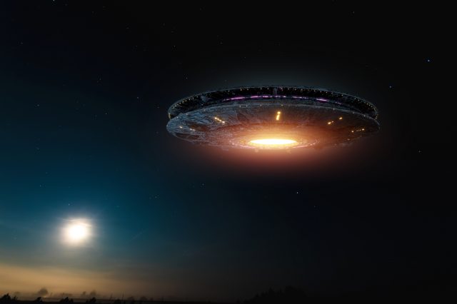 UFO, an alien plate soars in the sky, hovering motionless in the air. Depositphotos.