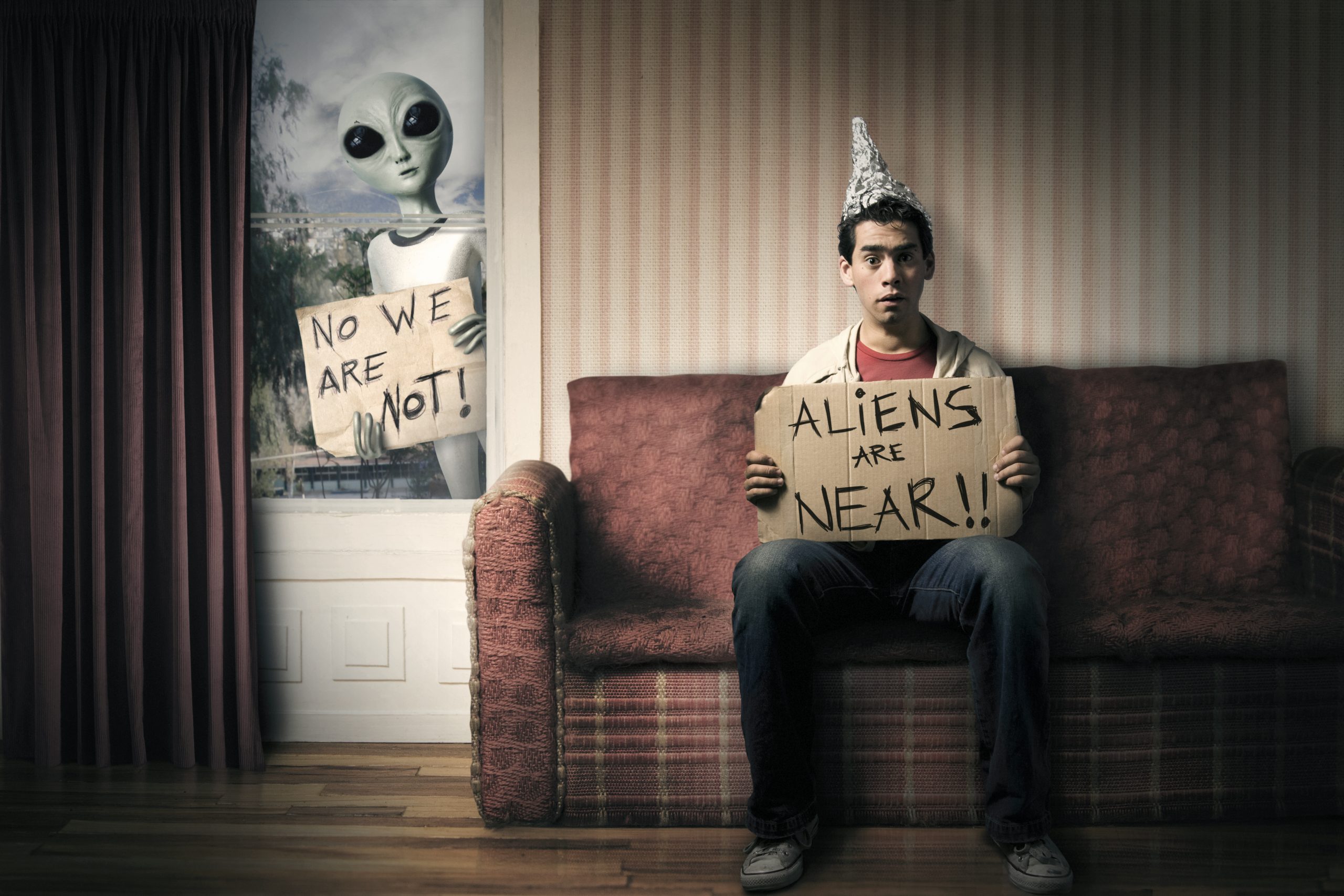 Guy holding a cardboard saying aliens are near.