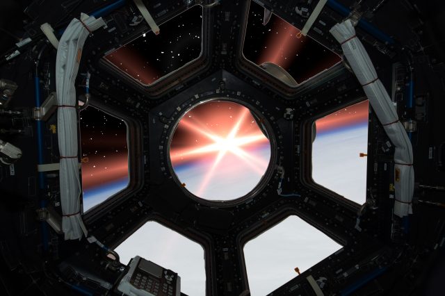 Artistic Rendering of a spacecraft window and a bright flash in space. Depositphotos.