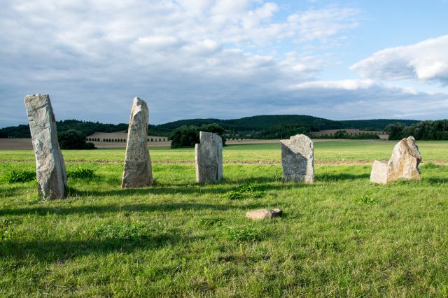Megalithic stones in Europe and a background of land ready for agriculture. Depositphotos.
