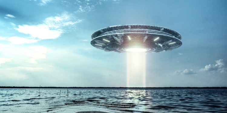 An artistic rendering of a UFO hovering in the sky. Depositphotos.