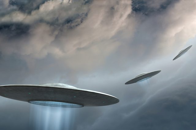 An illustration of three UFOs flying in the sky. Depositphotos.