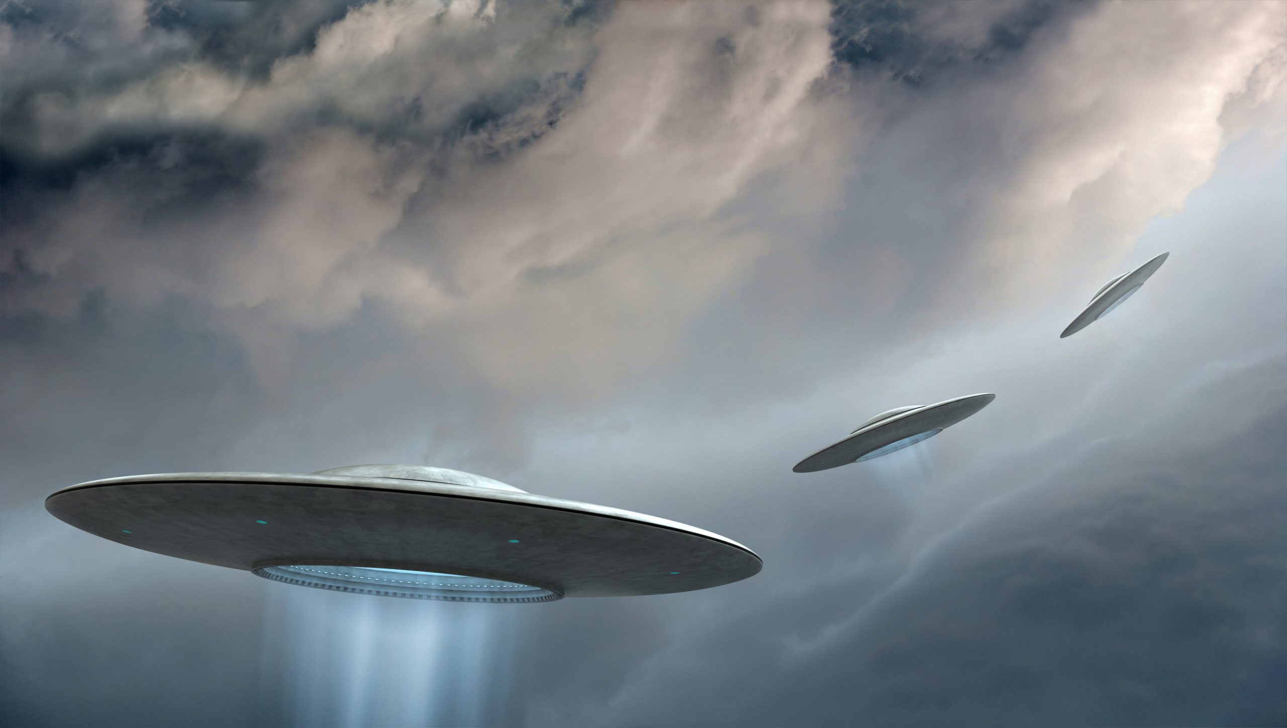 An illustration of three UFOs flying in the sky. Depositphotos.