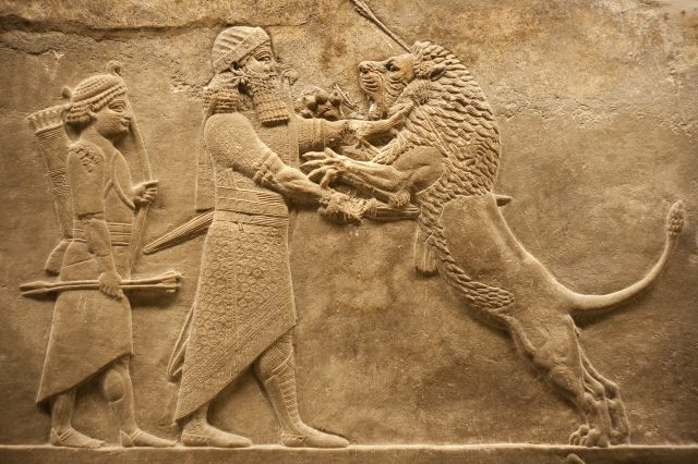Old relief representing an Assyrian warrior hunting lions. Depositphotos.