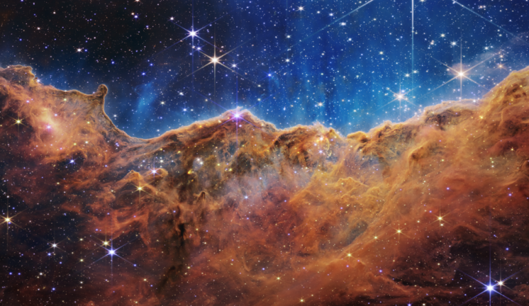 An edge of young, star-forming regions called NGC 3324 in the Carina Nebula can be seen in front of these 