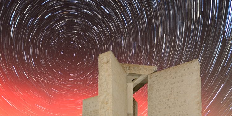 A photograph of the Georgia Guidestones and start rails in the sky. Depositphotos.