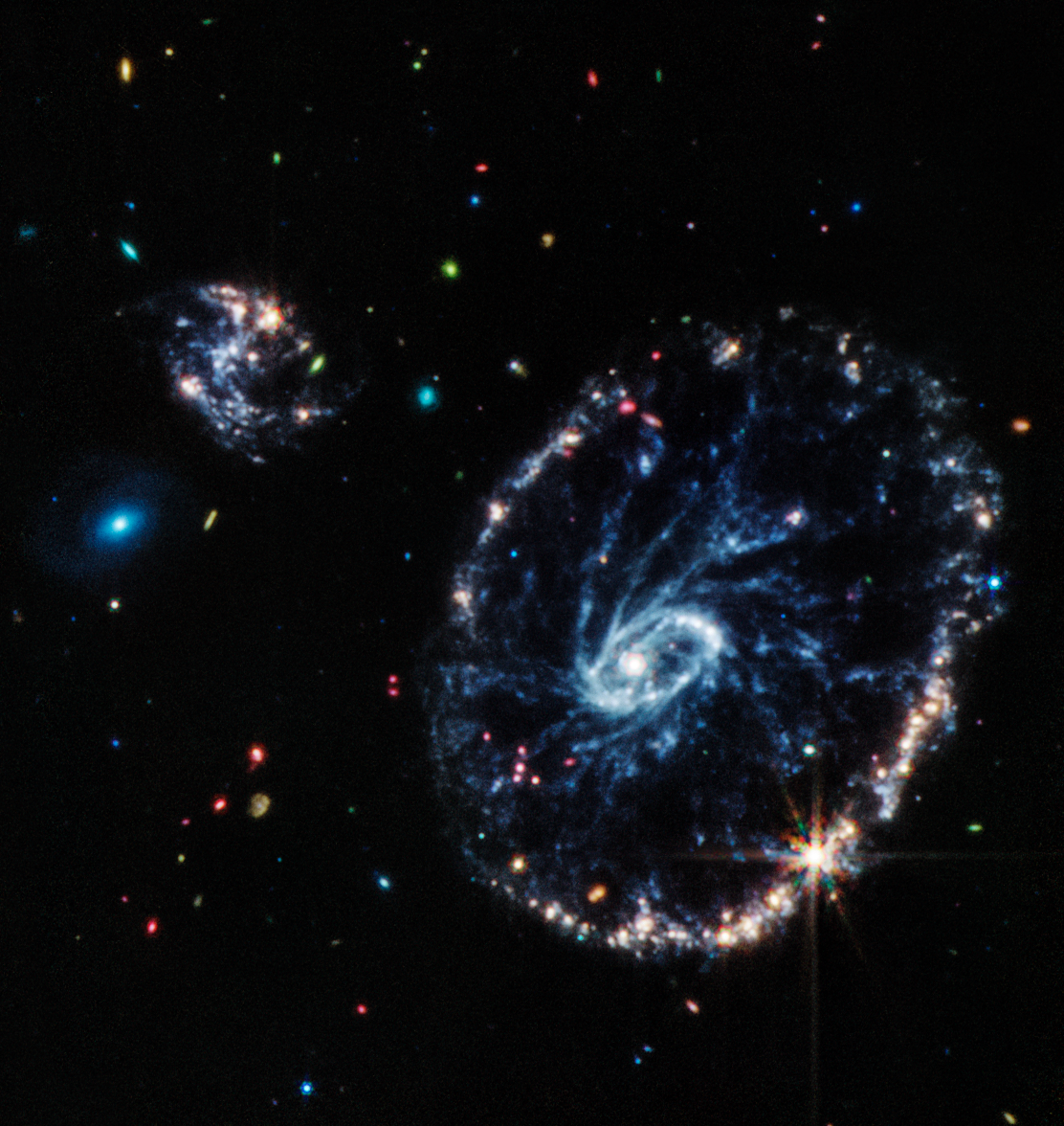 A large distorted ring-shaped galaxy (the Cartwheel) is illustrated in this image from the Mid-Infrared Instrument (MIRI) on Webb. Credits: NASA, ESA, CSA, STScI.