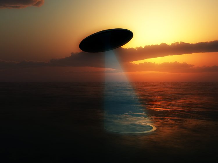 Illustration of a UFO absorbing water from a lake. Depositphotos.