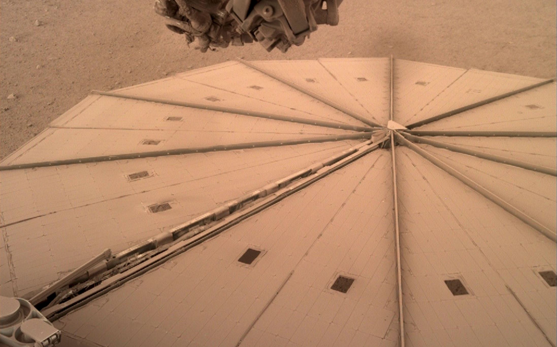 A photograph by InSight showing its solar panels covered in dust. Credit: NASA.
