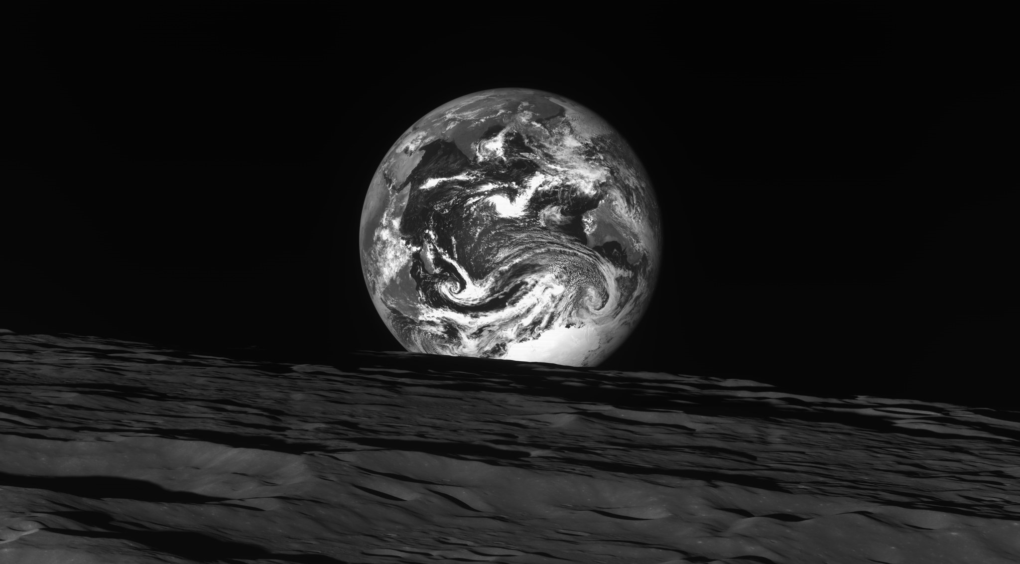 A black and white photograph of the Earth rising behind the Moon. Image Credit: Danuri/ South Korean Space Agency.