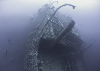 Divers exploring a shipwreck. YAYIMAGES.