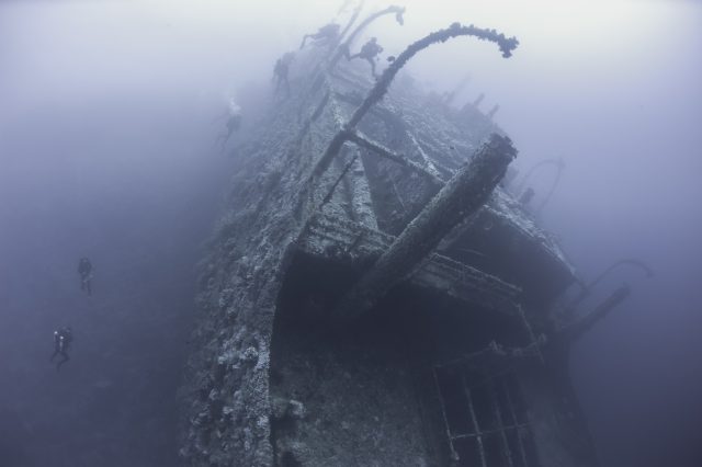 Divers exploring a shipwreck. YAYIMAGES.