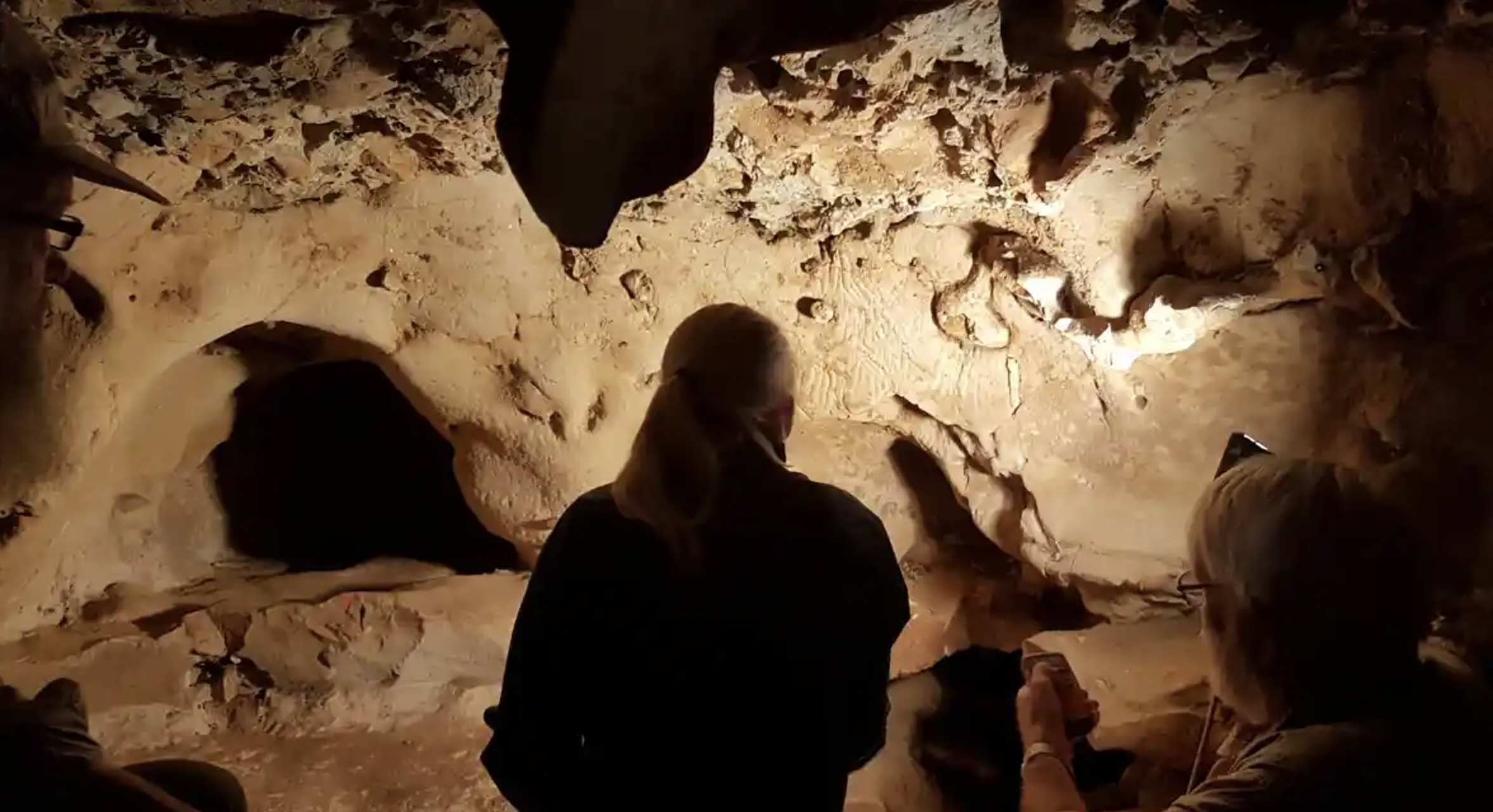 Researchers studying the mysterious symbols on the cave walls of the La Roche-Cotard cave in the picturesque Loire valley. Credit: Kristina Thomsen/SWNS.