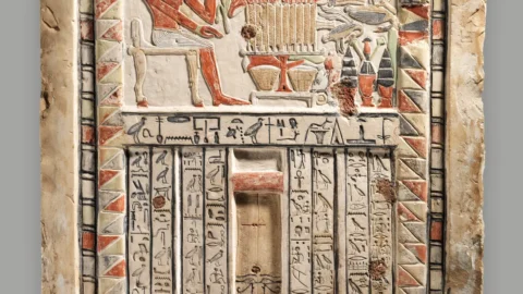 Painted limestone false door of the royal sealer Neferiu, with offering scenes and hieroglyphic inscriptions.