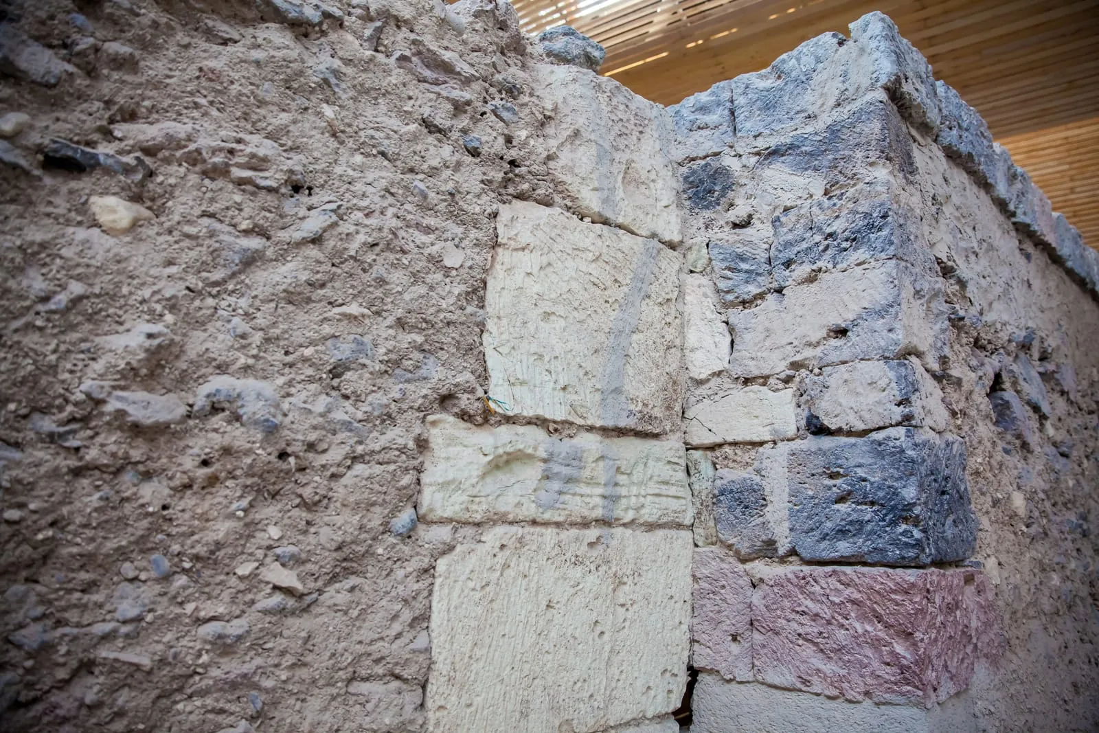 A close-up view of Akrotiri's ancient walls shows the use of differently colored stone blocks. The varying textures reflect advanced construction techniques and careful planning, unusual for a city over 3,500 years old.
