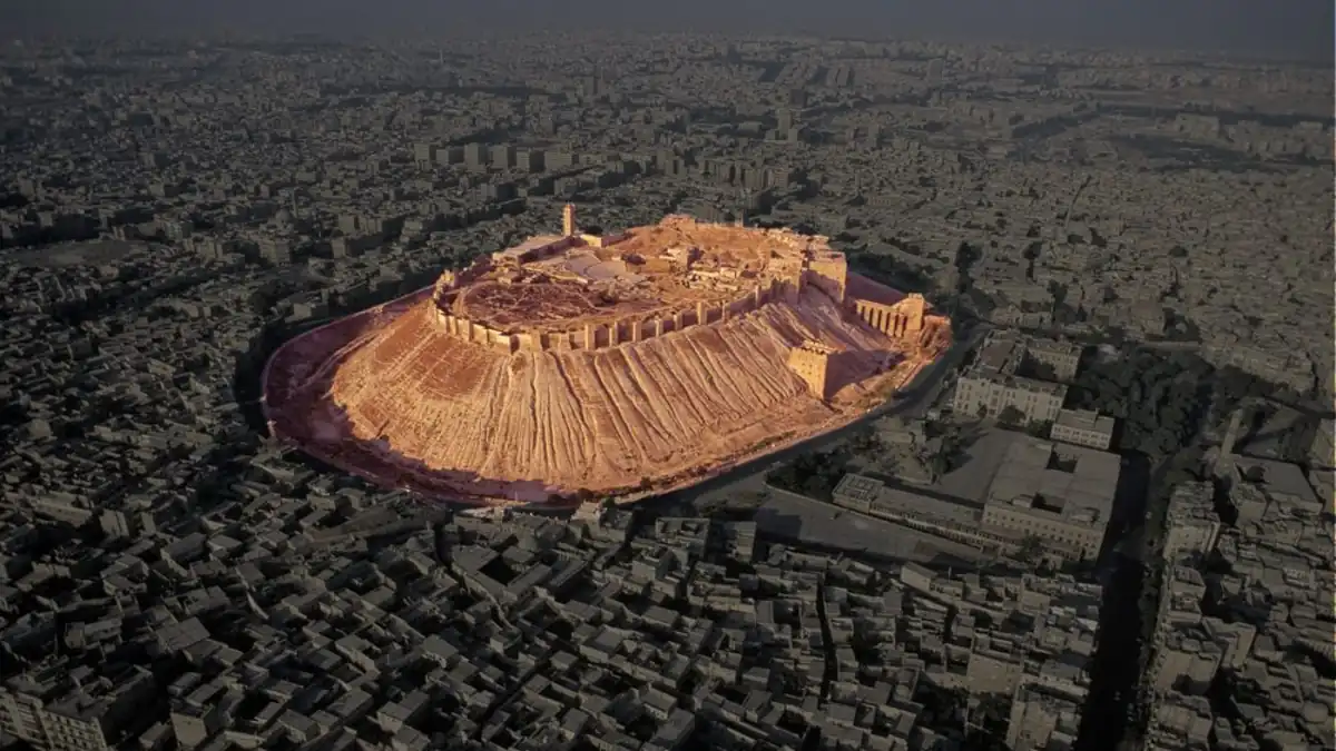 Aerial view of the Citadel of Aleppo above the surrounding city.