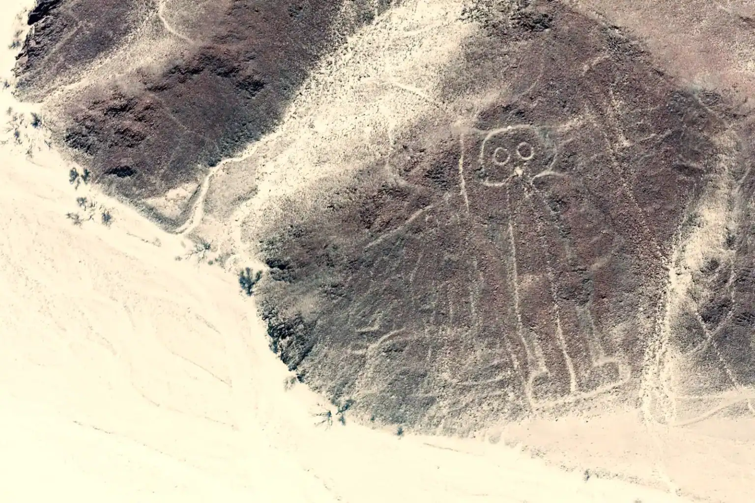 Aerial view of the Nazca “Astronaut” geoglyph on a desert hillside in southern Peru.