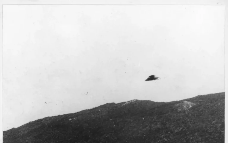 Historic black-and-white National Archives UAP record showing a dark object above a ridge