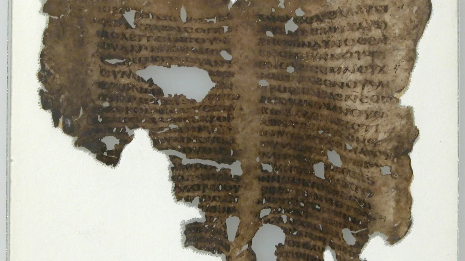 A worn medieval manuscript fragment with dark lines of handwritten text