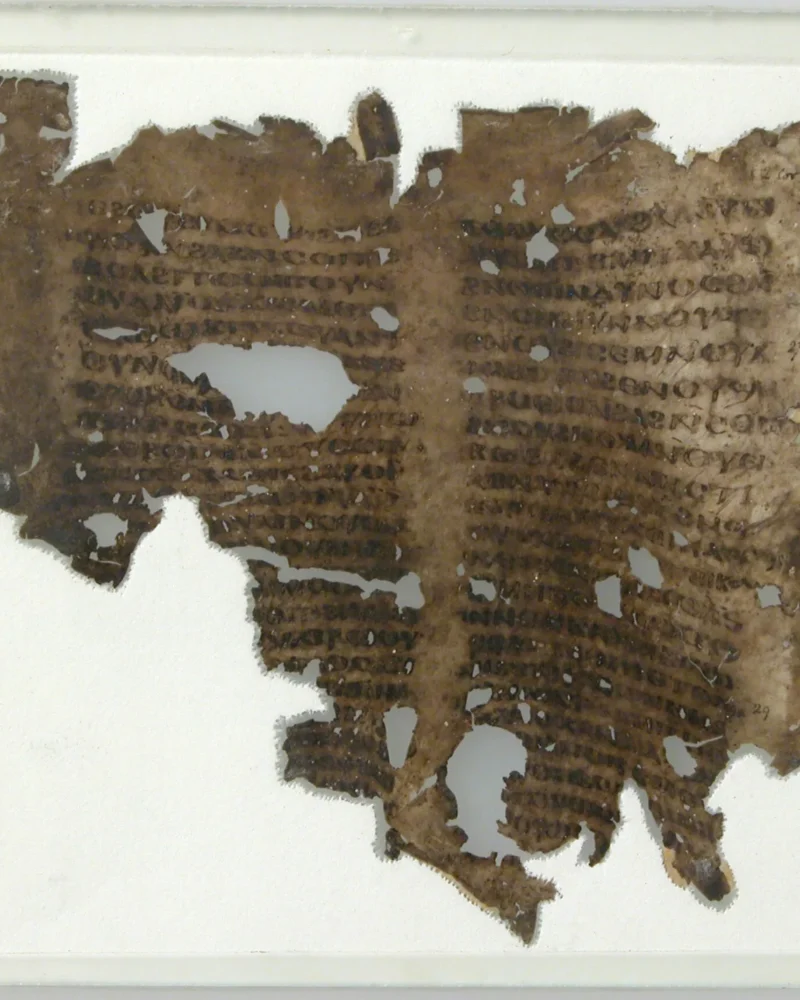 A worn medieval manuscript fragment with dark lines of handwritten text