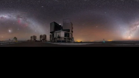 A modern optical telescope beneath a star-filled night sky