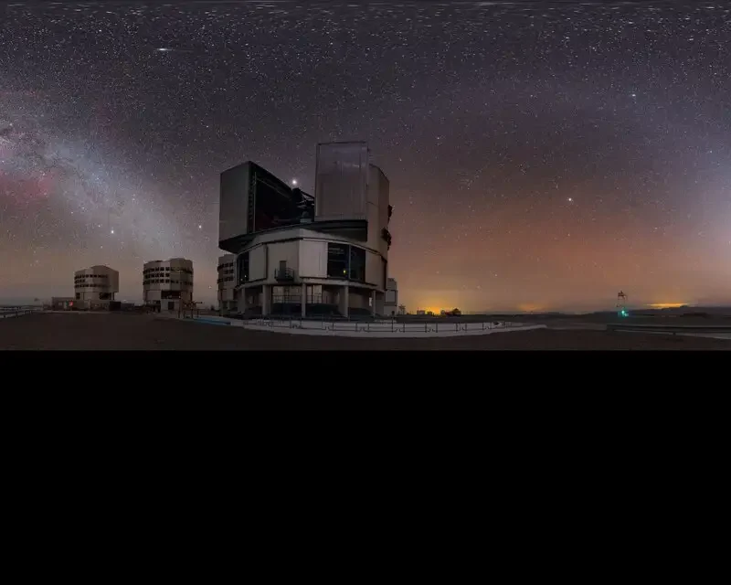 A modern optical telescope beneath a star-filled night sky