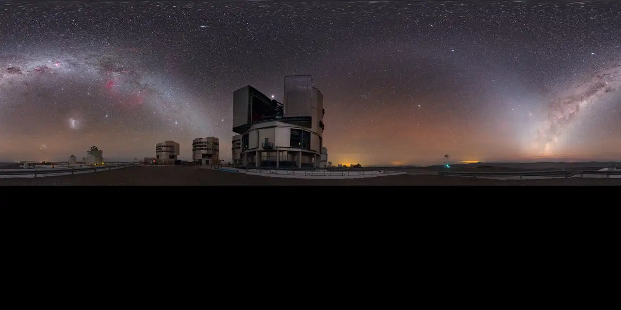 A modern optical telescope beneath a star-filled night sky