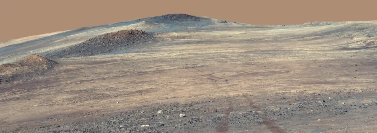 Wide Perseverance rover panorama of pale rocks and tracks at Broom Point on Mars