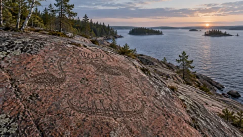 Interpretive illustration of Neolithic petroglyphs on a granite shore beside Lake Onega.