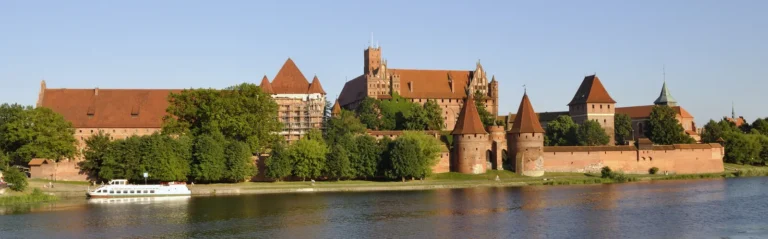 Panoramic view of Malbork Castle across the river