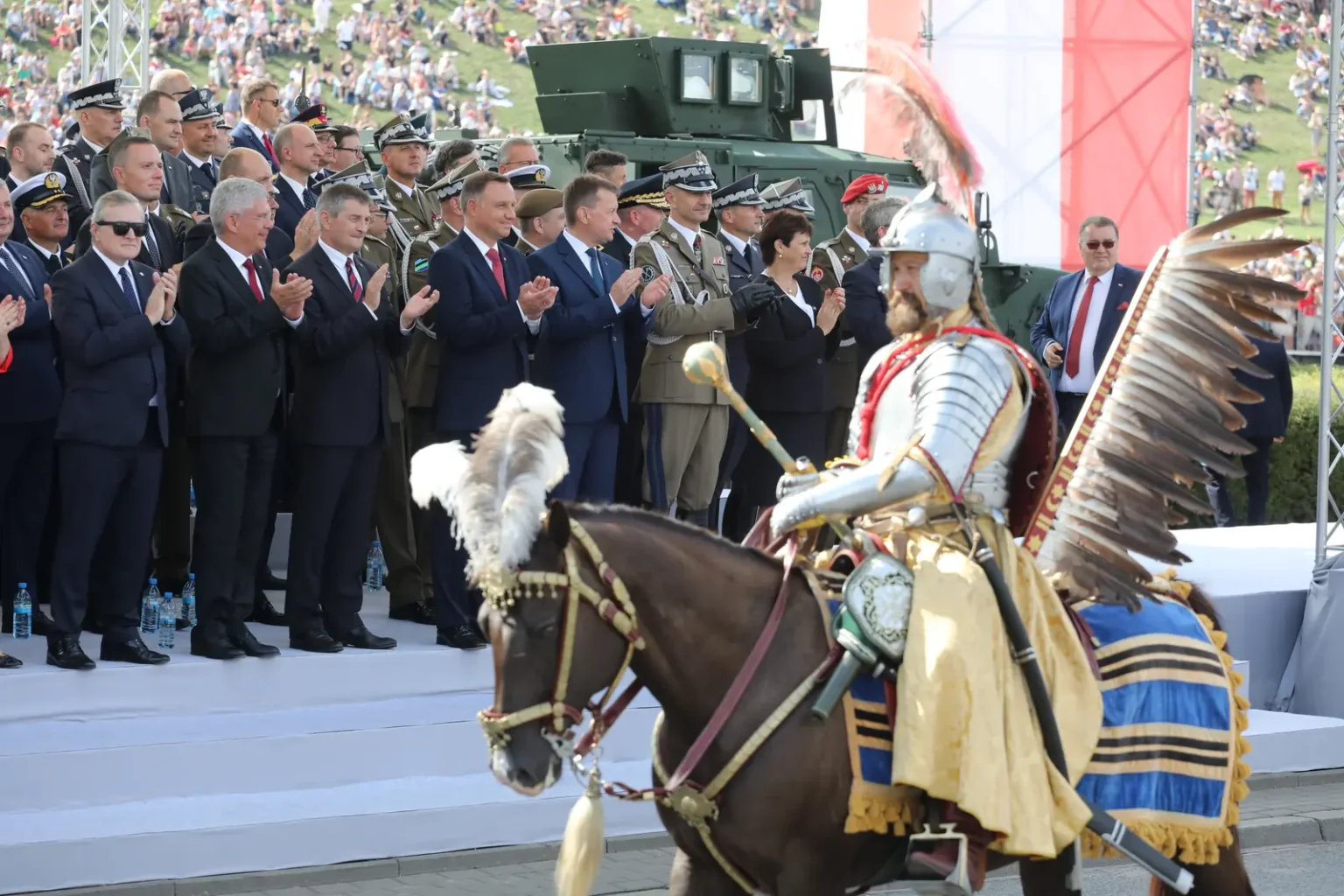A mounted reenactor in hussar armour with feathered wings at a modern Polish parade
