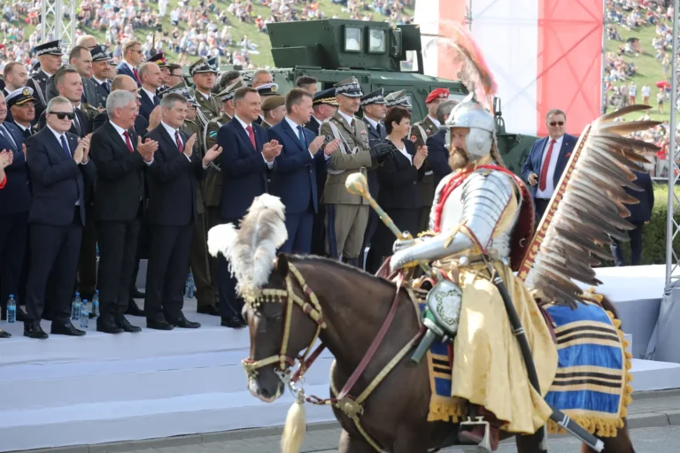 A mounted reenactor in hussar armour with feathered wings at a modern Polish parade
