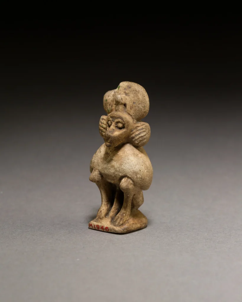 Small faience baboon figure with a disk and cobra above its head