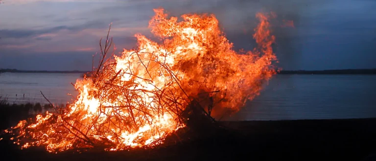 Walpurgis bonfire burning beside Lake Ringsjö at dusk