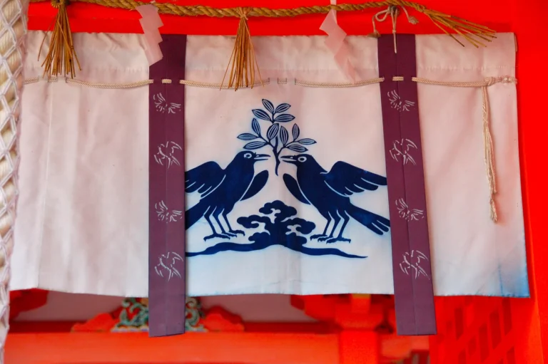 Blue crow motifs on white shrine fabric at Kumano Nachi Taisha